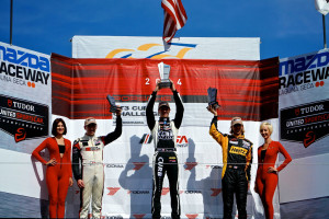 Michael Lewis holds high his trophy after earning the victory in the No. 98 Competition Motorsports/Curb-Agajanian Porsche 911 in the third race of the 2014 IMSA GT3 Cup Challenge USA by Yokohama season on Sunday, May 4. Photo by Blake Blakely.