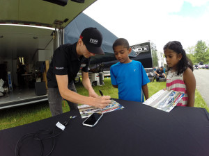 Michael Lewis makes some time from his busy race weekend schedule to meet and sign autographs for some young race fans.