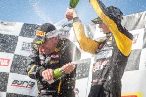 Preston Calvert (left) and Michael Lewis celebrate on the podium as they co-drove to two wins in the PWC SprintX category at Utah Motorsports Campus on August 13 and 14, 2016.
